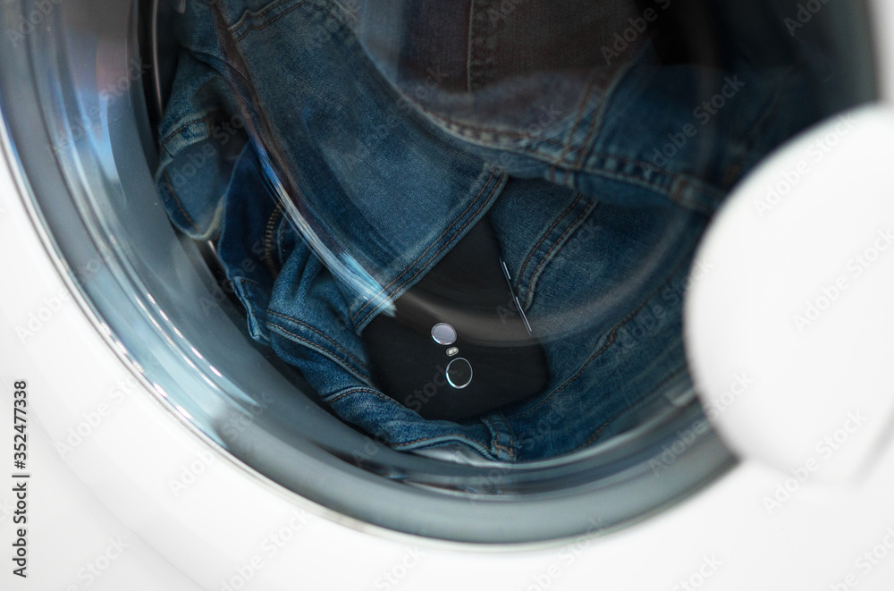 Forgotten phone in jeans in the washing machine. Forgotten phone in jeans in the washing machine.