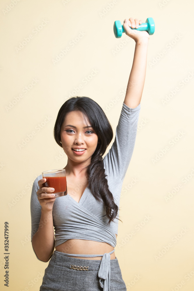 Healthy Asian woman with dumbbell and tomato juice. Healthy Asian woman with dumbbell and tomato juice.
