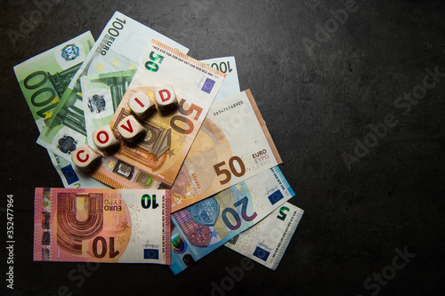euro banknotes on a dark background with covid inscription view from top