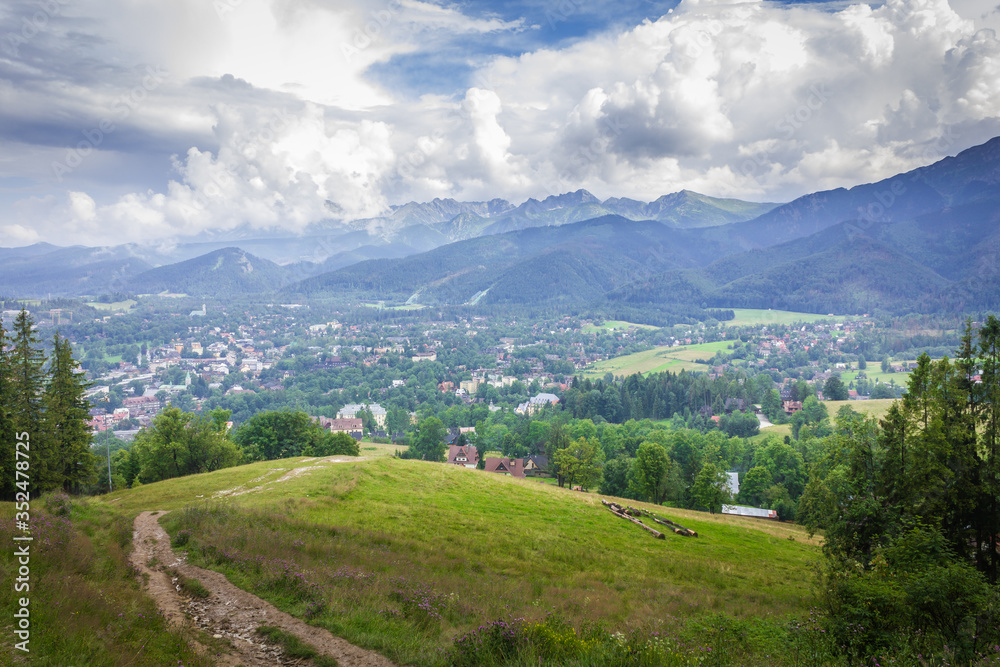 Obraz premium Poland. Polish Tatry mountains. View of the cloudy mountains. In the valley the city of Zakopane.