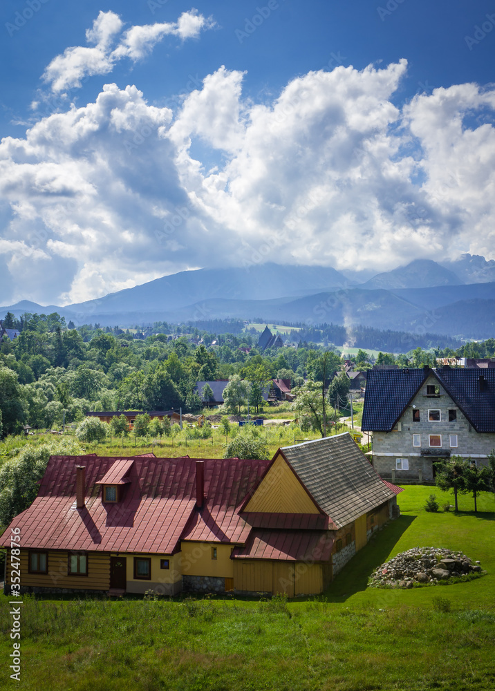 Poland. Polish Tatry mountains. View of the cloudy mountains. In the background houses.