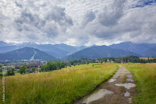 Poland. Polish Tatry mountains. View of the cloudy mountains. A dirt road, meadows.