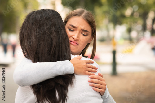 Foto Disgusted Girl Hugging Crying Girlfriend Pretending To Support Her Outdoors