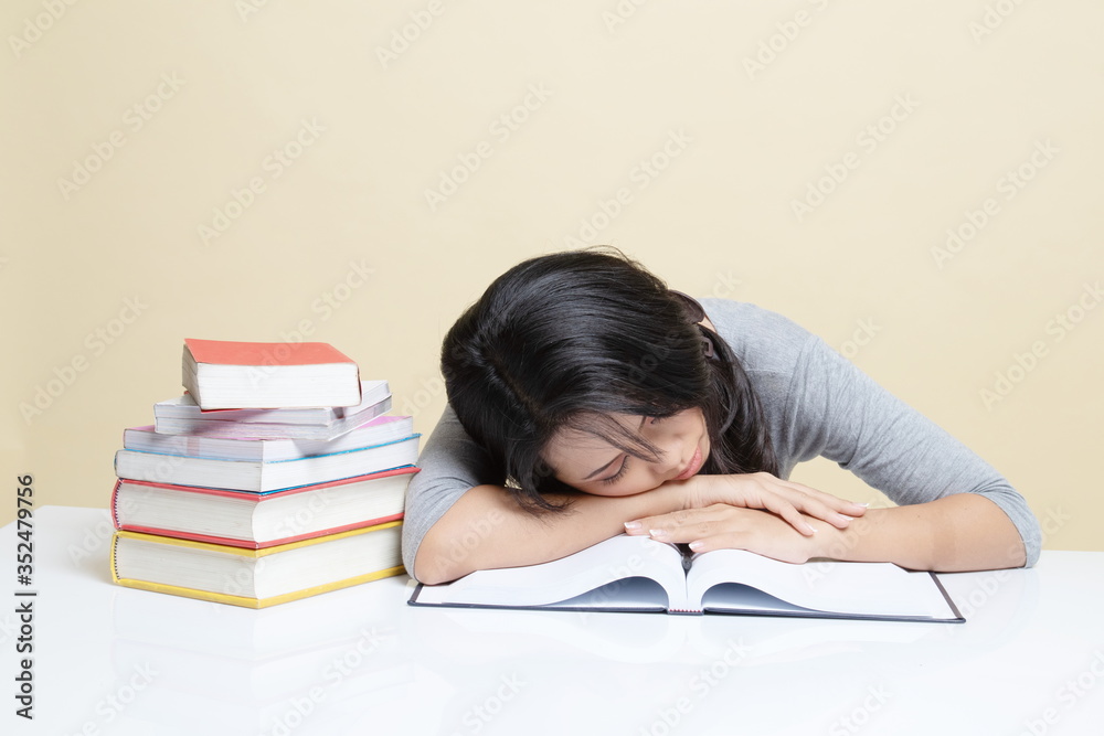 Exhausted Young Asian woman sleep with books on table. Exhausted Young Asian woman sleep with books on table.