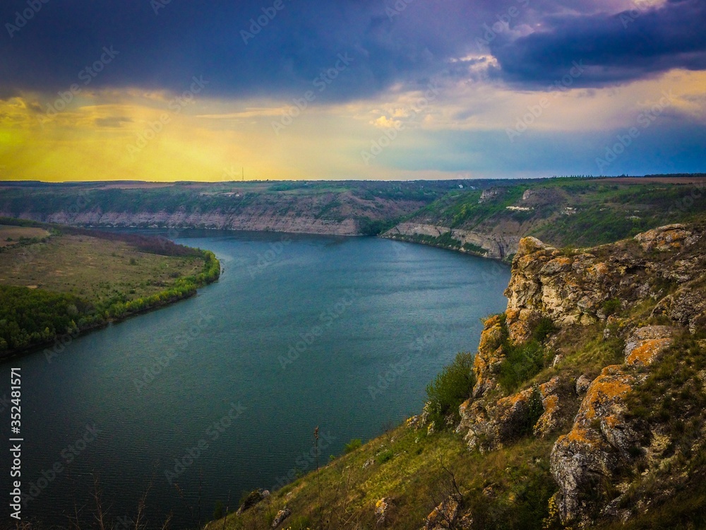 Panoramic view from the hill on bend of the river. Beautiful summer landscape. Colorful clouds of the morning sky. Dniester Canyon located at the territory of Dniester River Panoramic view from the hill on bend of the river. Beautiful summer landscape. Colorful clouds of the morning sky. Dniester Canyon located at the territory of Dniester River