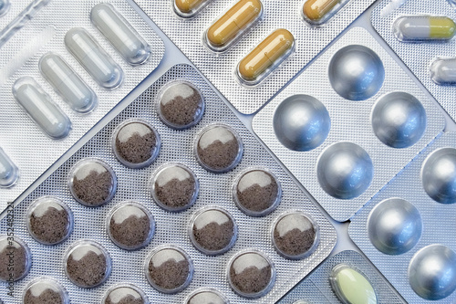 Various blisters with tablets on a medical table. Pills, medicine and health. Virus protection concept. Flat lay, top view, close-up.