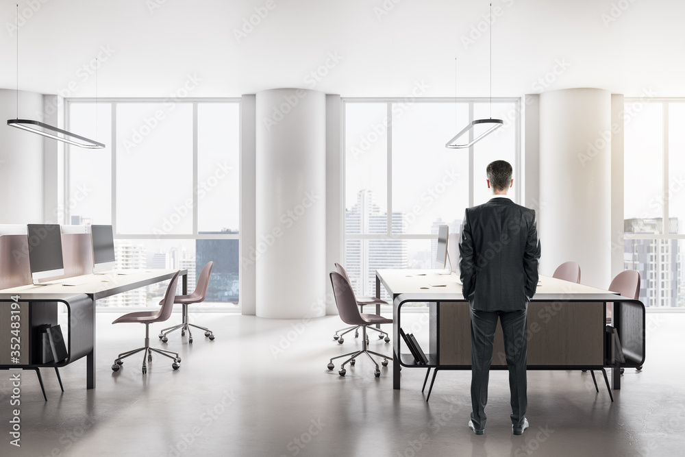 Young businessman standing in modern office interior