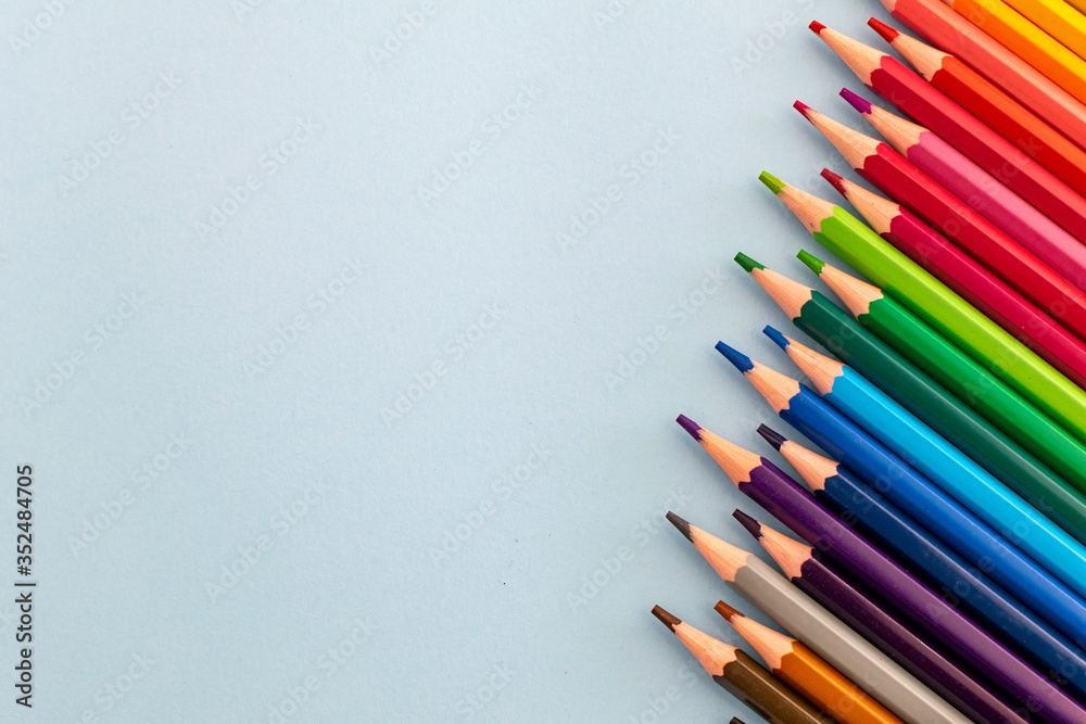 a selection of colourful pencils lined up in a row at a slant a selection of colourful pencils lined up in a row at a slant