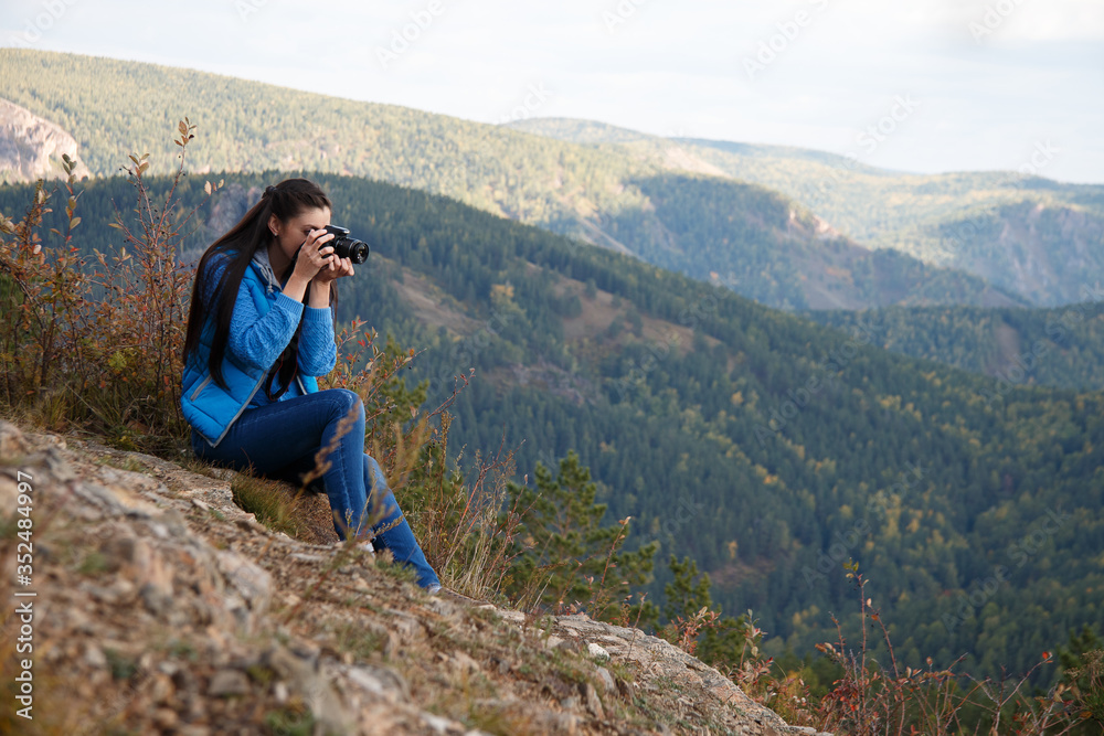 girl photographer takes pictures high in the mountains