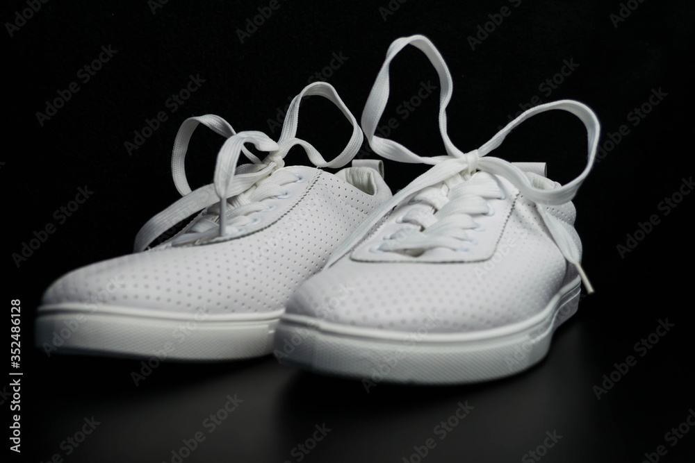 White sneakers on a black background.