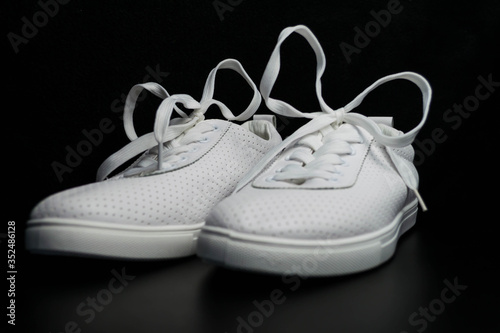 White sneakers on a black background.