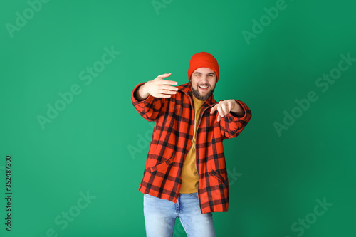 Handsome young man dancing against color background