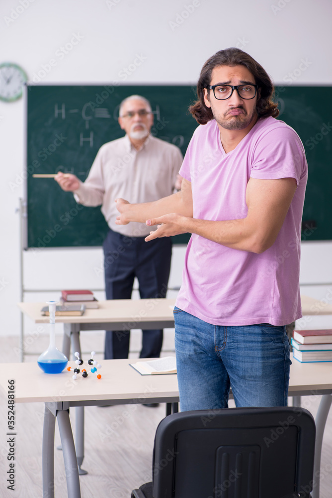 Fototapeta premium Old chemist teacher and two students in the classroom