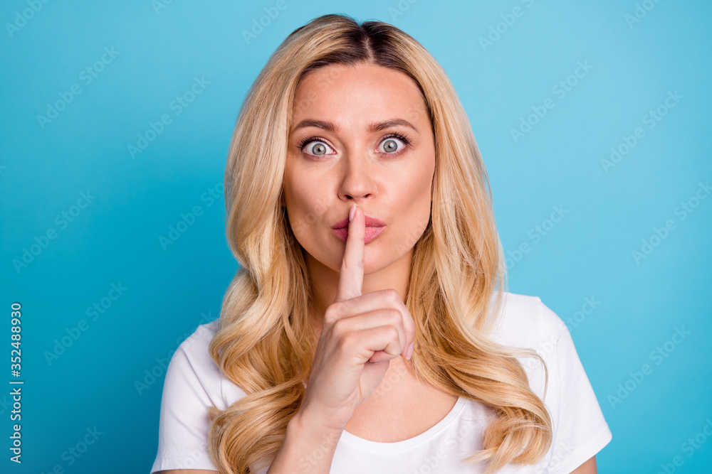 Portrait of funny funky woman hear incredible secret ask dont share novelty put index finger mouth wear good look clothes isolated over blue color background Portrait of funny funky woman hear incredible secret ask dont share novelty put index finger mouth wear good look clothes isolated over blue color background