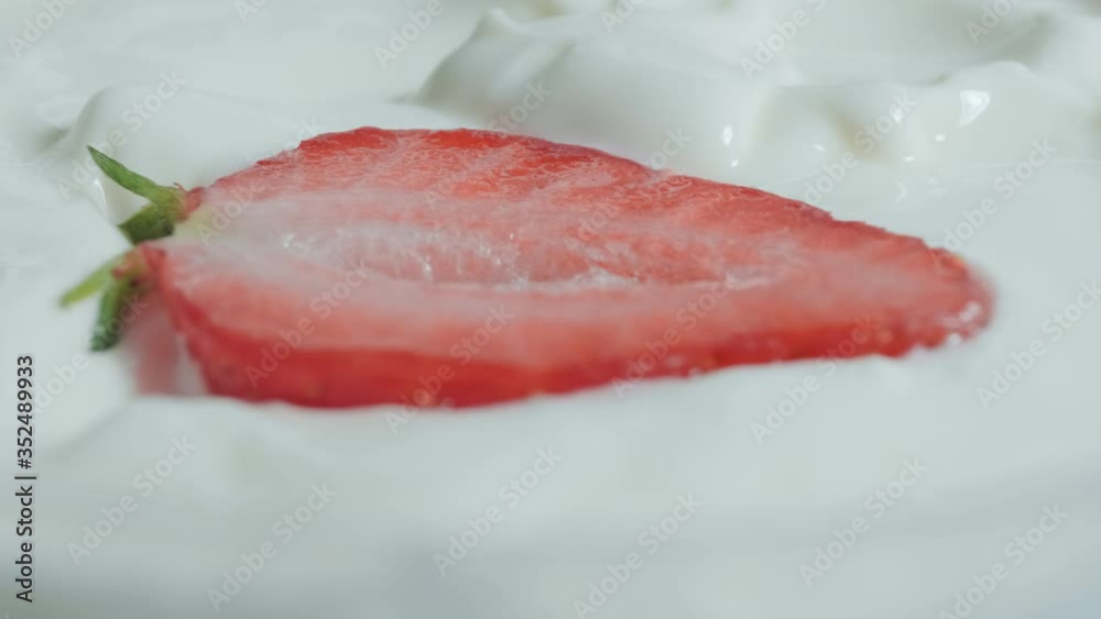 Fresh strawberries cut in half fall into yogurt. Organic ripe strawberry. Close up Fresh strawberries cut in half fall into yogurt. Organic ripe strawberry. Close up