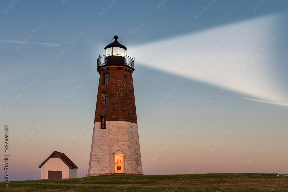 Lighthouse beam at sunset. Point Judith lighthouse, Rhode Island, USA