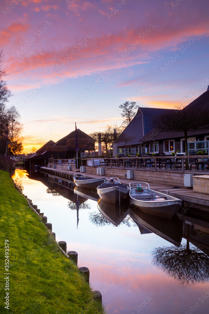 Canal with boats at sunset in the beautiful village of Githroom in the Netherlands