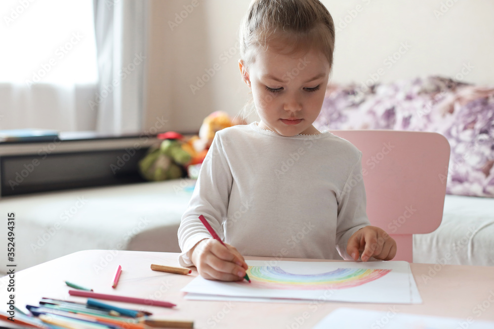 Girl painting rainbow at home, a symbol of UK National Health Service (NHS). Thanks to the doctors for their work. Stay at home Social media campaign. Girl painting rainbow at home, a symbol of UK National Health Service (NHS). Thanks to the doctors for their work. Stay at home Social media campaign.