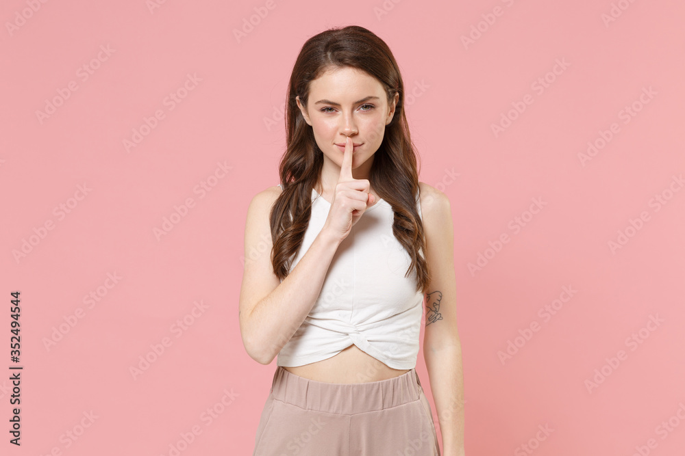 Secret young brunette woman girl in light casual clothes posing isolated on pastel pink background. People lifestyle concept. Mock up copy space. Saying hush be quiet with finger on lips shhh gesture. Secret young brunette woman girl in light casual clothes posing isolated on pastel pink background. People lifestyle concept. Mock up copy space. Saying hush be quiet with finger on lips shhh gesture.