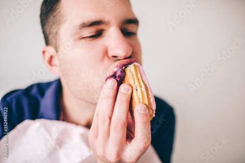 Young man isolated over background. Close up cut view portrait of guy divour eat sweet tasty delicious cake. Enjoying meal.