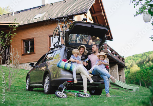 Family with two small children and dog going on cycling trip in countryside.