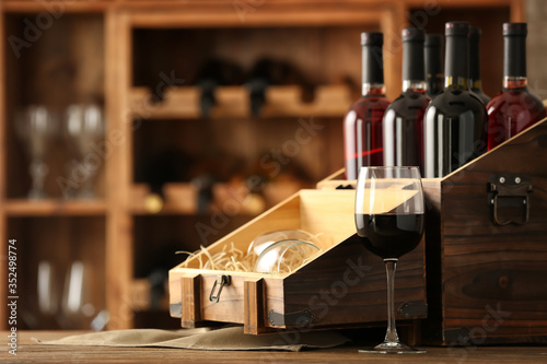 Box with bottles of wine on table in cellar