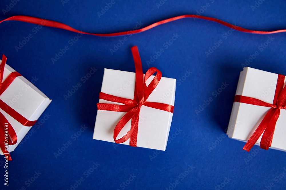 Fototapeta premium Luxury white gift boxes with red ribbon