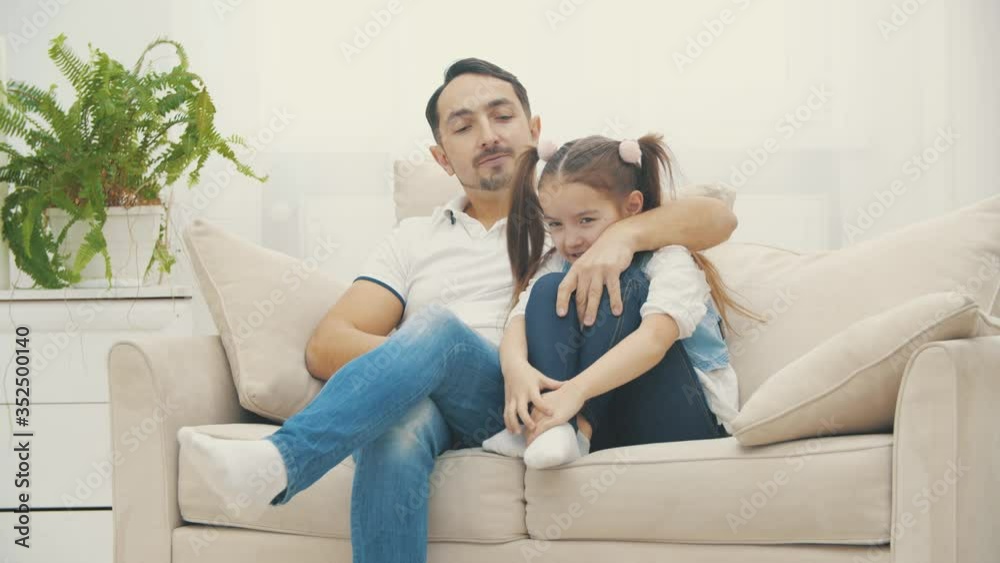 Nice daddy hugging his beautiful daughter on a coach in 4k slowmotion video. Nice daddy hugging his beautiful daughter on a coach in 4k slowmotion video.