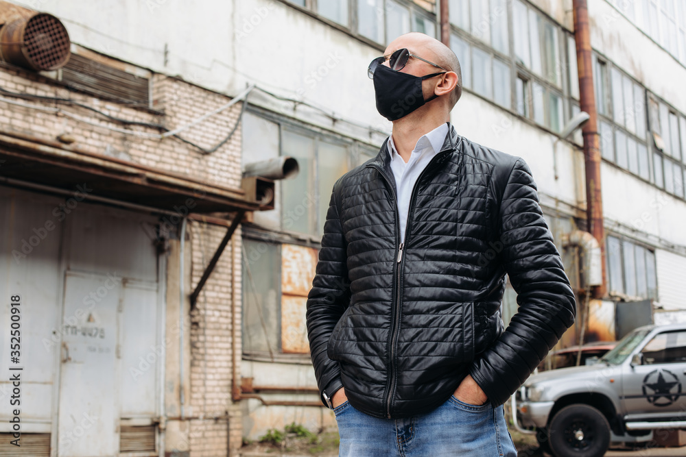 The man wears a black protective mask.The mask prevents corona virus and air pollution by dust.