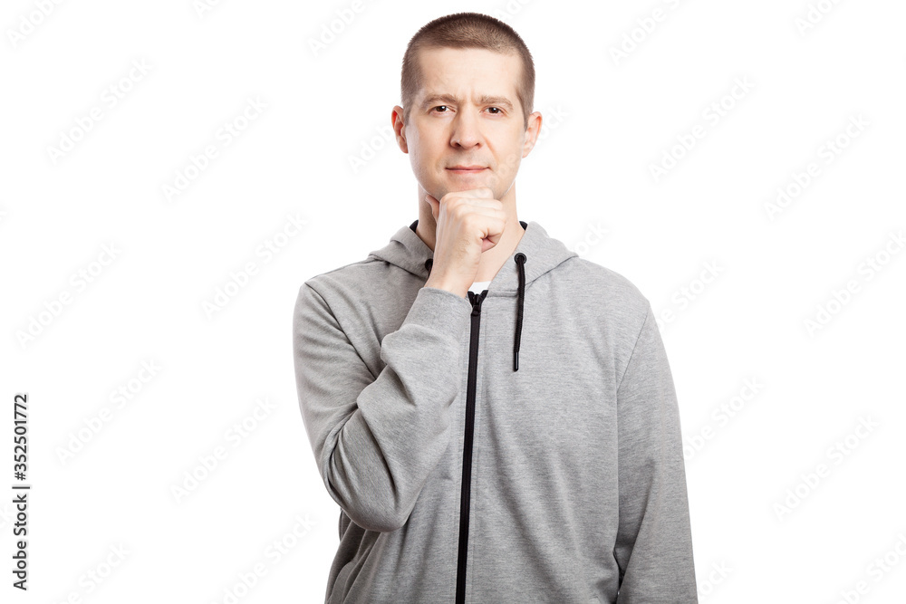 brooding, insecure male athlete makes a decision, a hand at the chin. Dressed in a grey hooded jacket. A look into the camera. Isolated brooding, insecure male athlete makes a decision, a hand at the chin. Dressed in a grey hooded jacket. A look into the camera. Isolated