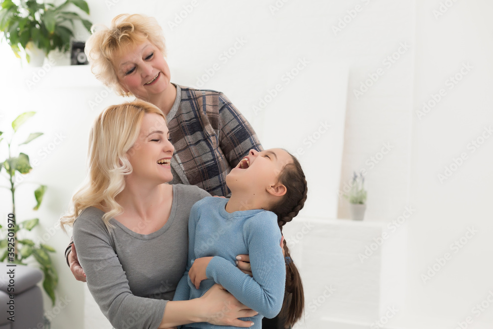 Portrait of three generations of women look at camera posing for family picture, cute little girl hug mom and granny enjoy time at home, smiling mother, daughter and grandmother spend weekend together Portrait of three generations of women look at camera posing for family picture, cute little girl hug mom and granny enjoy time at home, smiling mother, daughter and grandmother spend weekend together
