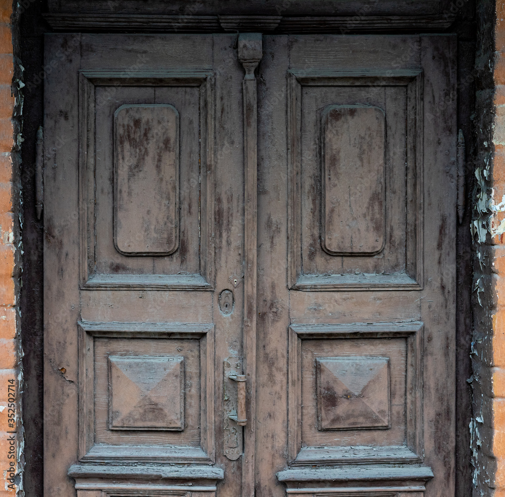 Old wooden doors are painted brown with colorless paint