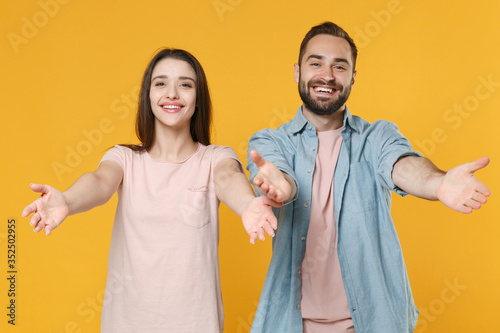 Schilderij op canvas Smiling young couple two friends guy girl in pastel blue casual clothes isolated on yellow background