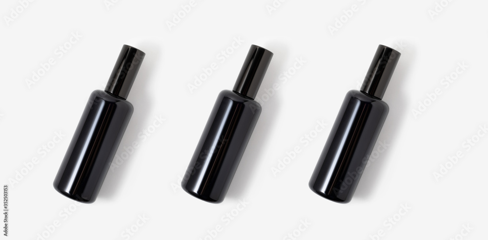 Three black glass cosmetic or parfum spray bottles on white background. Face, body skin or hair care. Health and beauty. Spa and cosmetology. Detox.