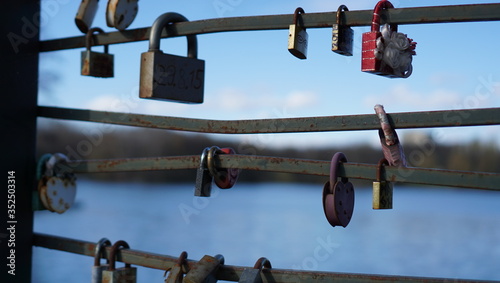 Locks of love are on the bridge over the river in the city center with blurred background. photo