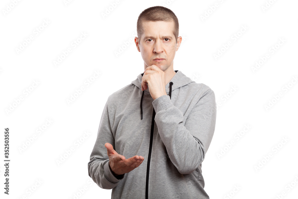 thoughtful, calm man athlete makes a decision, hand stretched forward, the other at the chin. Dressed in a grey hooded jacket. A look into the camera. Isolated thoughtful, calm man athlete makes a decision, hand stretched forward, the other at the chin. Dressed in a grey hooded jacket. A look into the camera. Isolated