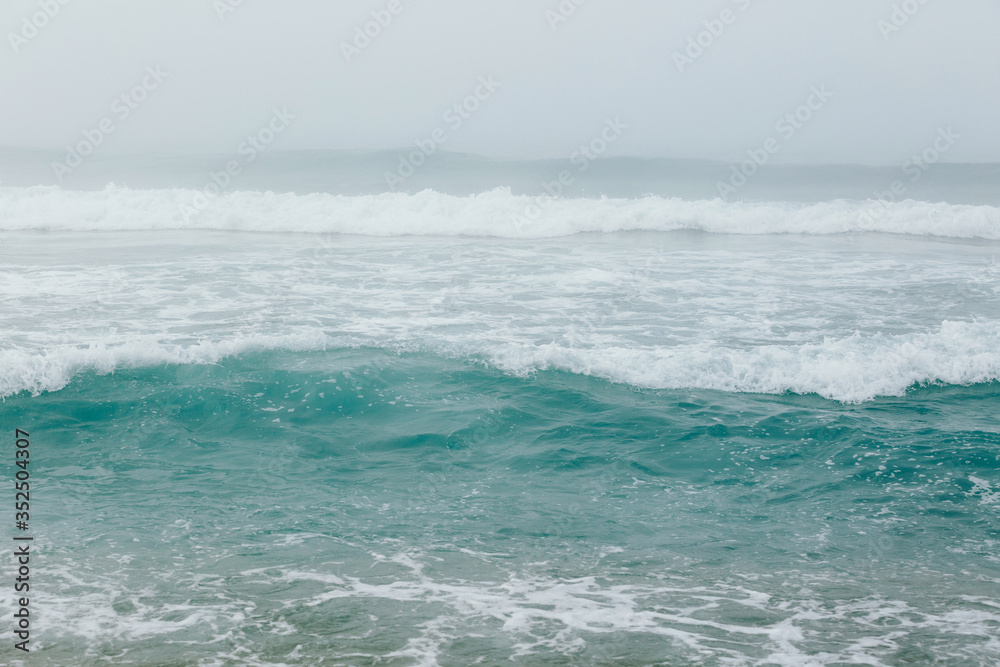 Aqua blue ocean waves background. Сlear sea water. Foggy weather. Copy space for text