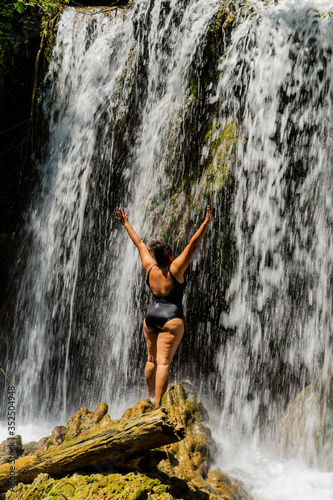 woman enjoying nature next to a waterfall
