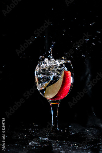 Falling apple splashes in water.