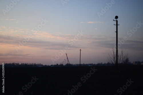 tilted power pole against the evening sky