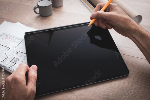 Konstfotografi Tablette tenue en main par un architecte  qui dessine avec un stylet en travaill