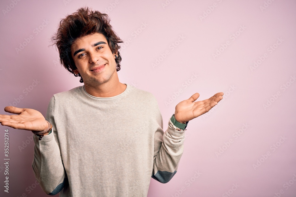Young handsome man wearing casual t-shirt standing over isolated pink background clueless and confused expression with arms and hands raised. Doubt concept. Young handsome man wearing casual t-shirt standing over isolated pink background clueless and confused expression with arms and hands raised. Doubt concept.