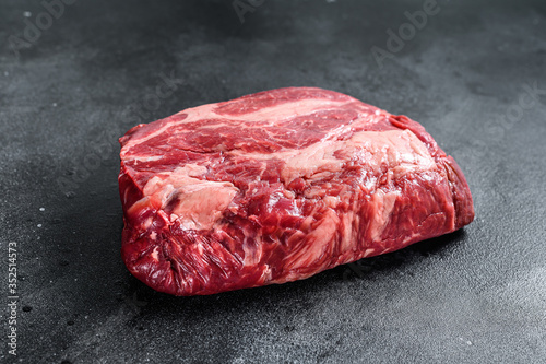 Fresh Raw meat Prime Black Angus Chuck roll steak. Black background. Top view