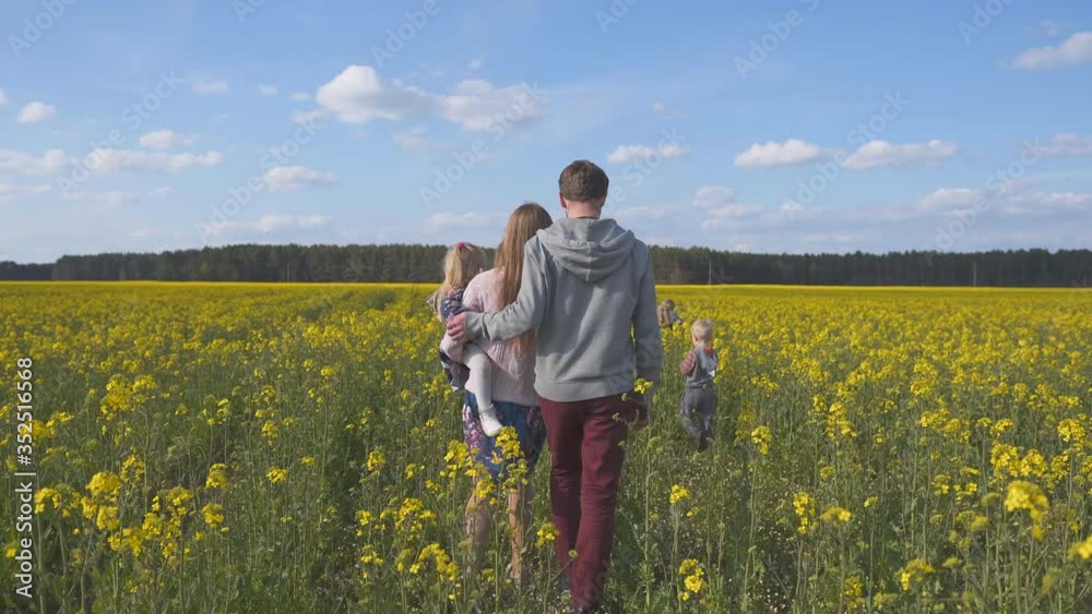 A happy family walks on a rapeseed field. A happy family walks on a rapeseed field.