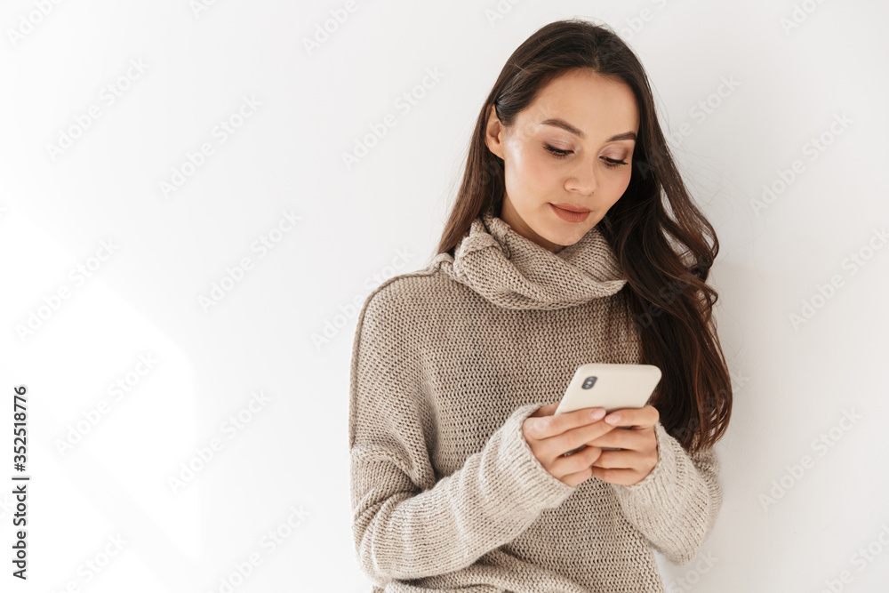 Image of pleased asian woman posing and using smartphone Image of pleased asian woman posing and using smartphone