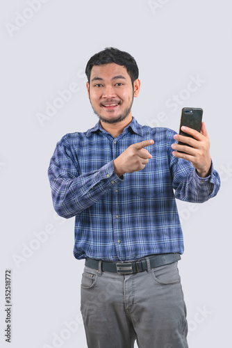 Asian men wearing blue striped shirts smile happy holding smartphones © background photo