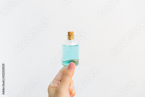 Girl hand holding alcohol bottle on white background, hand sanitizer, covid 19