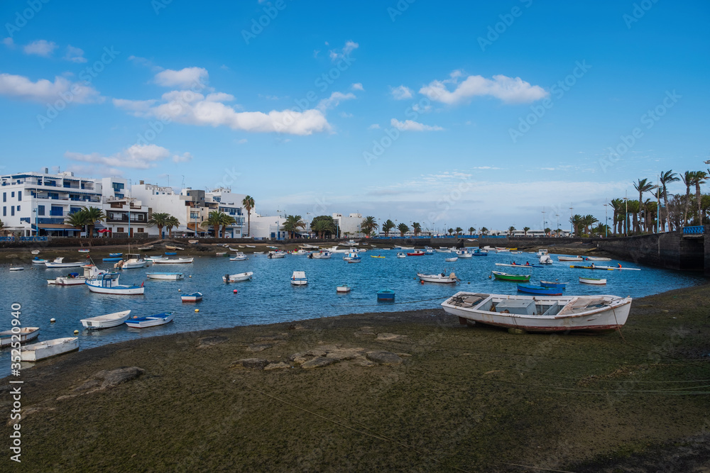 Fisher boats at the laguna Charco de San Gines at sunset, city of Arrecife, Lanzarote, Canary Islands. October 2019