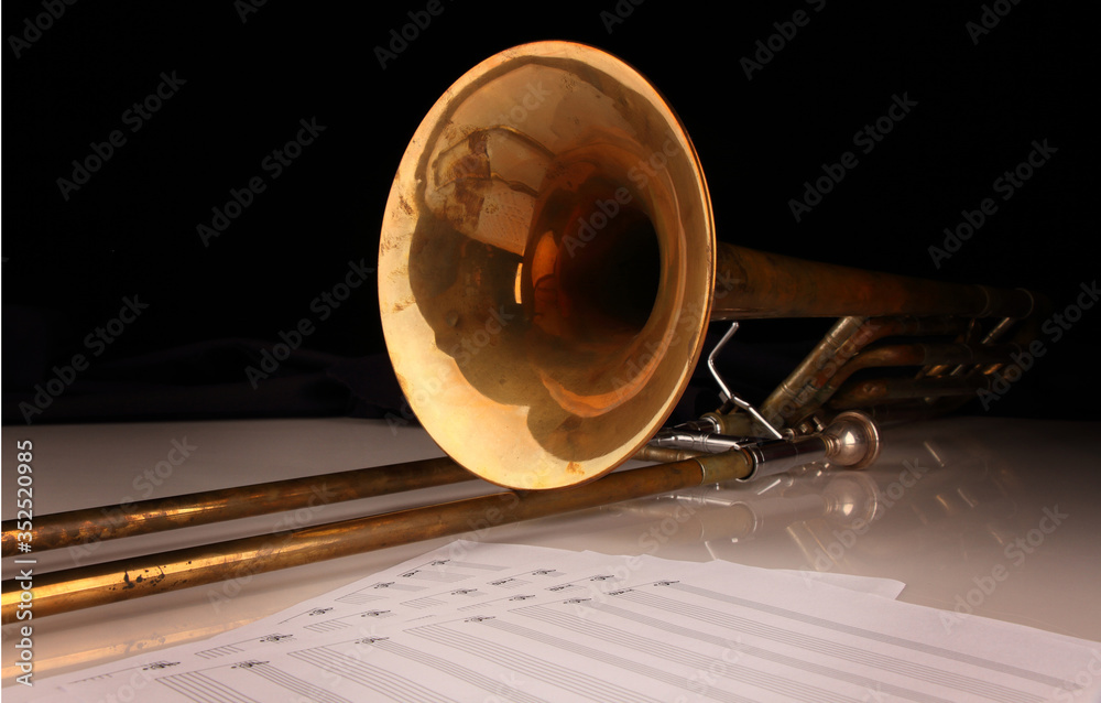Naklejka premium Trombone on a white glossy table