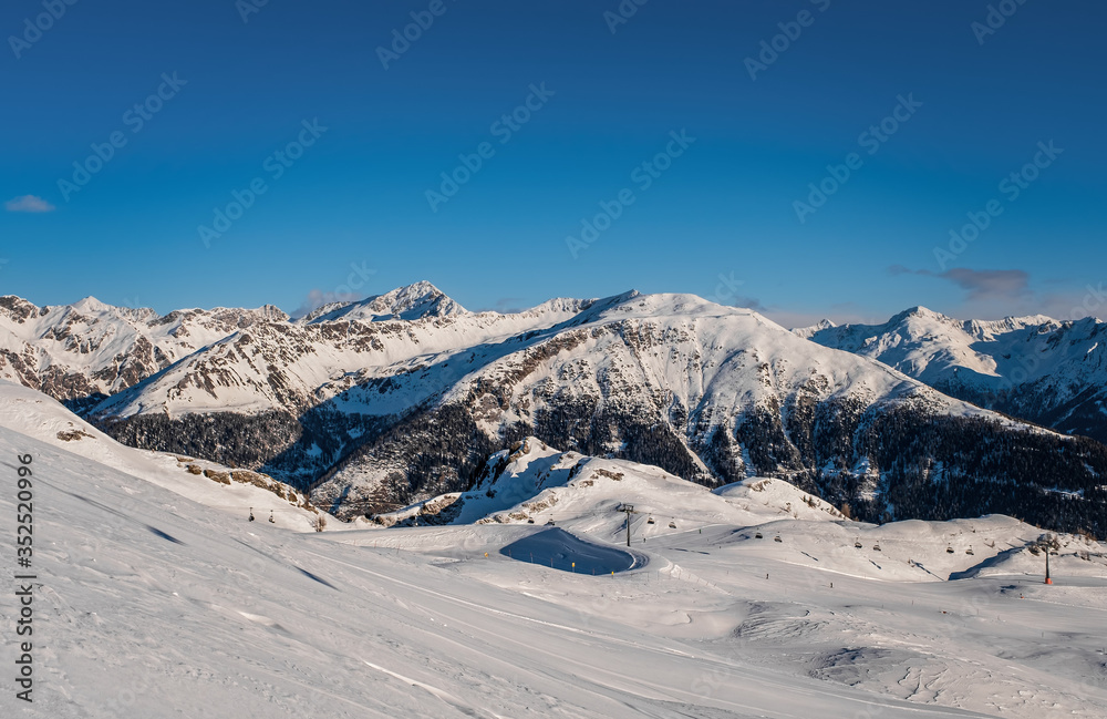 January 2020 Sillian, Austria: snowy ski run on the foreground, blue sky on the background
